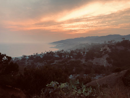 Magical Sunset Over Coastal Hills With Soft Clouds and Distant Waves Near Malibu, Capturing Nature's Beauty and Tranquilityの写真素材