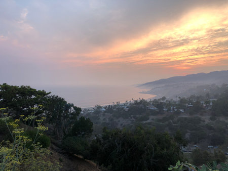 Sunset View Over Coastal Landscape With Lingering Mist and Vibrant Colors in the Skyの写真素材