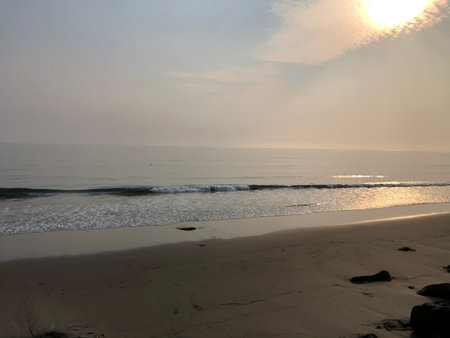 Calming Morning at the Beach With Gentle Waves and Soft Sunlight Illuminating the Shorelineの写真素材