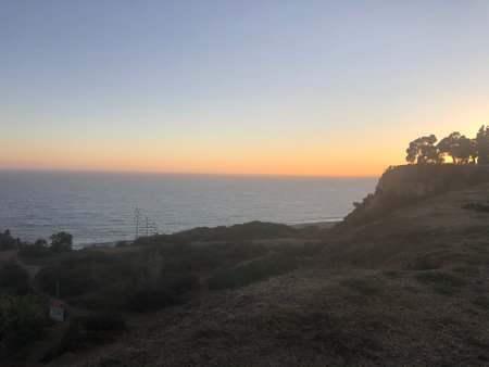 Sunset Over the Ocean Creates a Serene Atmosphere Along the Coastal Cliffs in a Tranquil Evening Sceneの写真素材