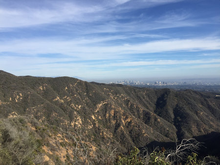 Stunning Mountain View Overlooking a Sprawling City Skyline Bathed in Soft Sunlightの写真素材