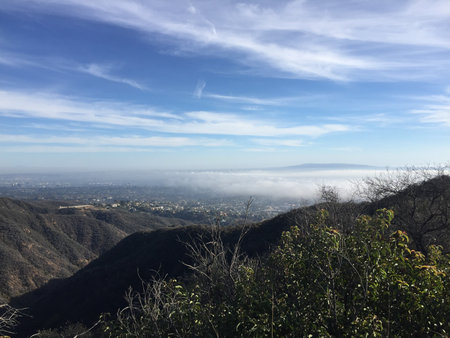 Dramatic Mountain View Capturing a Misty Valley Under a Bright Sky in Californiaの写真素材