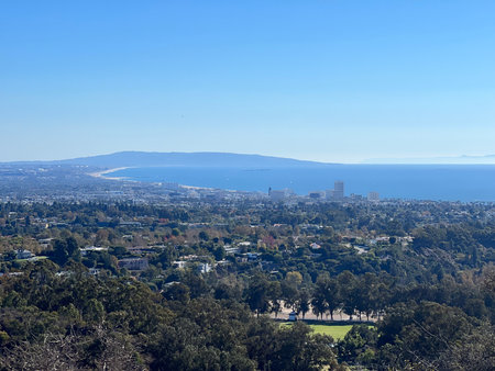 Scenic Overlook of Coastline and City Skyline Shining Under Clear Blue Sky on a Sunny Dayの写真素材