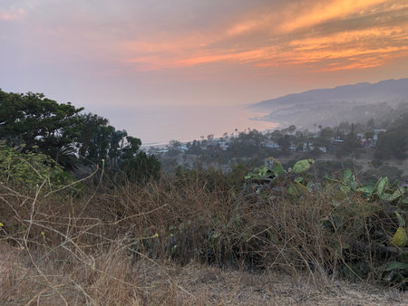 Sunset Over the Coastline Reveals Tranquil Beauty of Nature at Dusk Near the Hillsの写真素材