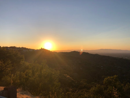 Sunset Over the Hills Creating a Golden Glow in the Early Evening Skyの写真素材