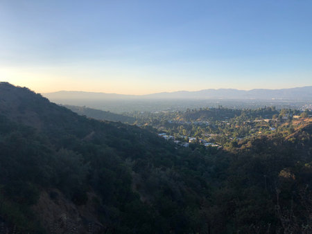 Mountain Landscape at Sunset Revealing a Serene Valley Nestled Below Under a Peaceful Skyの写真素材