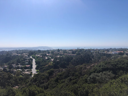 Stunning Panoramic View of Lush Greenery and Coastal Landscape Under a Clear Blue Skyの写真素材
