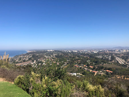 Breathtaking Coastal View From the Hills Showcasing the Stunning Landscape of City and Ocean During a Clear Sunny Dayの写真素材