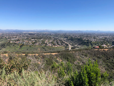 Breathtaking View of Sprawling Cityscape and Mountains Under a Clear Blue Sky During Midday in a Peaceful Nature Settingの写真素材