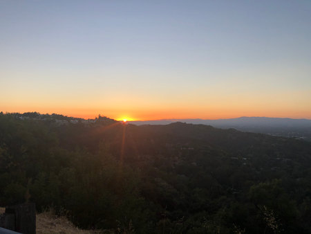 Majestic Sunset Casting Golden Light Over Rolling Hills and Valleys Near a Peaceful Overlookの写真素材