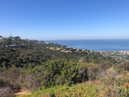 Scenic Coastal View From a Hillside Overlooking the Ocean and Countryside During Bright Daylightの写真素材