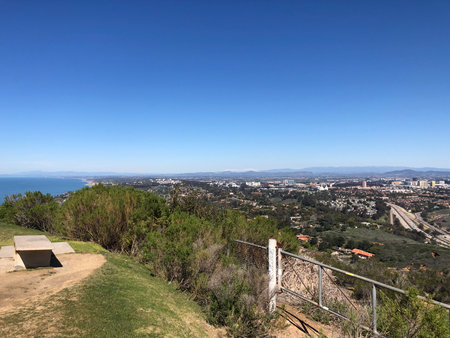 Scenic View of Coastal City From Hilltop With Clear Skies and Distant Mountains on a Sunny Dayの写真素材