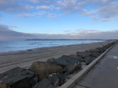 Morning Serenity Along the Sandy Shores of a Tranquil Beach at Sunrise With Gentle Waves Lapping the Shorelineの写真素材