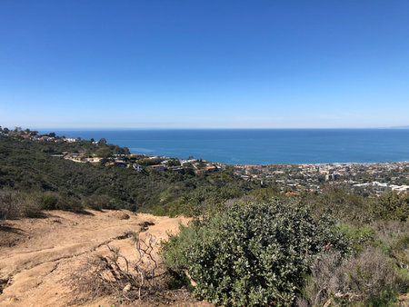 Scenic Coastal View From a Hiking Trail Overlooking the Ocean and City Below on a Clear Sunny Dayの写真素材