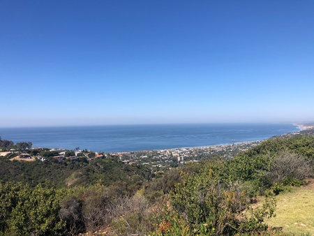 Scenic Coastal View From a Hillside Overlooking the Ocean and the Distant Shoreline With Clear Blue Skiesの写真素材