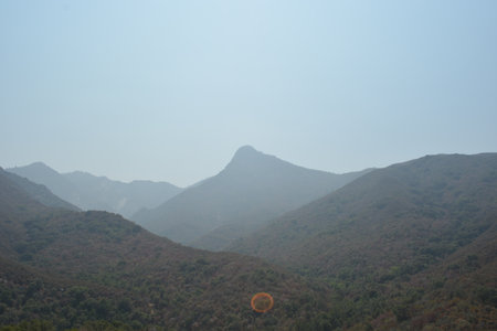 Scenic View of Majestic Mountains Under a Hazy Sky at Middayの写真素材