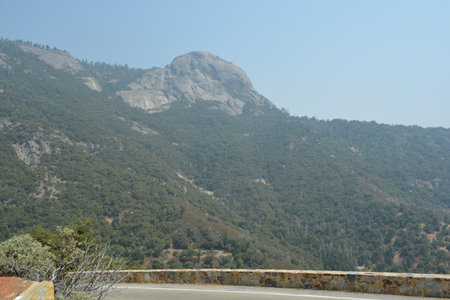 Majestic Mountain View Along a Winding Road in a Serene Natural Landscape at Middayの写真素材