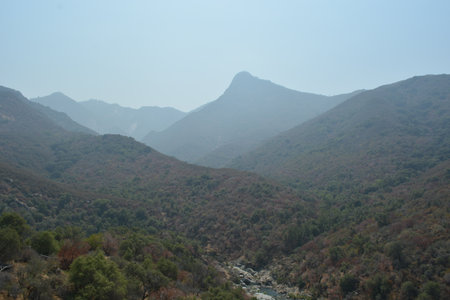 Beautiful Landscape of Rolling Mountains Under a Clear Sky at Midday in a Tranquil Valley Settingの写真素材
