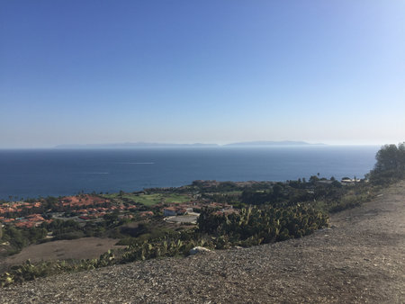 Scenic Coastal View From a Hillside Overlooking Tranquil Waters and Distant Islands During a Bright Sunny Dayの写真素材