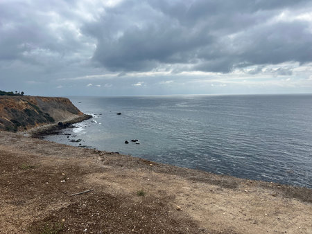 Serene Coastal View Under an Overcast Sky at a Rocky Shoreline Near the Oceanの写真素材