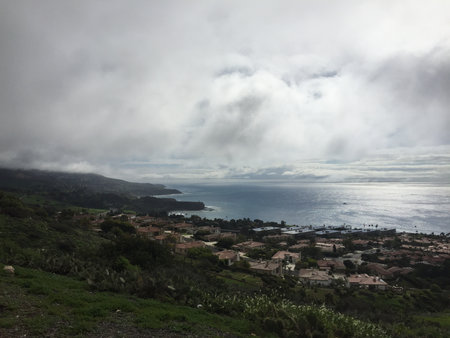 Beautiful Coastal View With Cloudy Skies and Serene Waters Along the Hillsideの写真素材