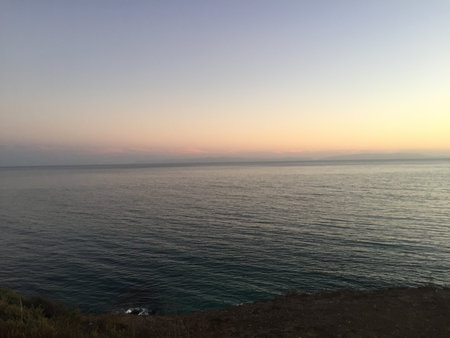 Serene Sunset Over Calm Ocean Waters at the Coastline, Inviting Peace and Reflectionの写真素材