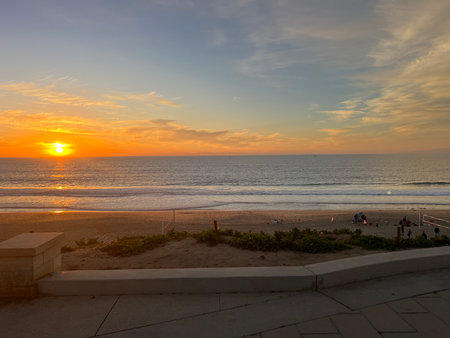 Sunset Over a Tranquil Beach With Soft Waves and a Peaceful Atmosphere in the Evening Skyの写真素材