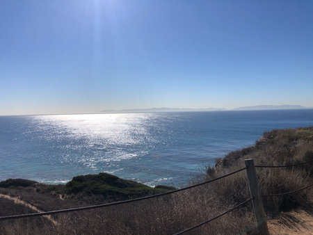 Expansive Ocean View From Rocky Cliffs Under a Bright Sun During Middayの写真素材