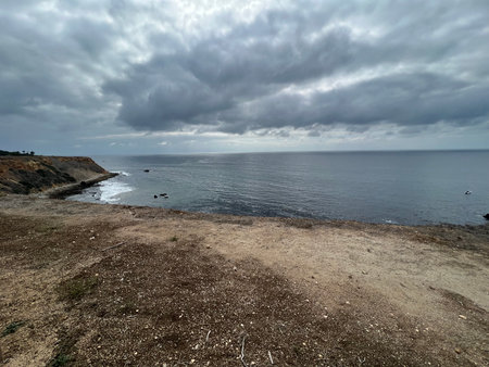 Serene Coastal Landscape Showing a Calm Sea Beneath an Overcast Sky at Middayの写真素材