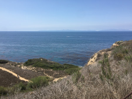 Coastal Hike Offers Stunning Views of the Ocean and Distant Mountains, Inviting Adventure on a Sunny Dayの写真素材