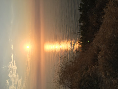Sunset Over the Serene Ocean Horizon Paints the Sky With Warm Hues Near the Coastal Cliffsの写真素材