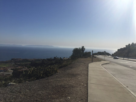 Stunning Coastal View With Clear Skies and Calm Waters by the Roadsideの写真素材