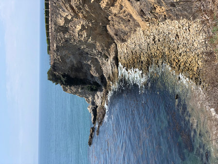 Breathtaking Coastal View Showcasing Rugged Cliffs and Clear Blue Waters by a Sunny Afternoonの写真素材