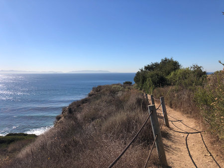 Sunshine Illuminating the Coastal Trail With Views of the Deep Blue Ocean on a Clear Sunny Dayの写真素材