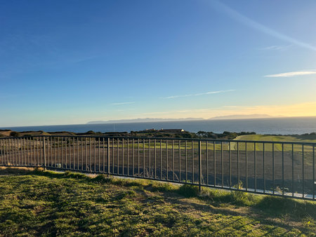 Beauty of a Coastal Sunset Over a Peaceful Landscape With a Distant Island Viewの写真素材