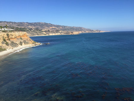Serene Coastal View at Sunset Showing Cliffs and Clear Waters Along the Shoreの写真素材
