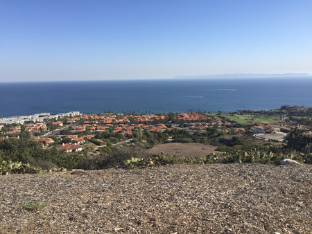 Scenic View of Coastal Houses and Blue Ocean Under a Clear Sky During a Sunny Afternoonの写真素材
