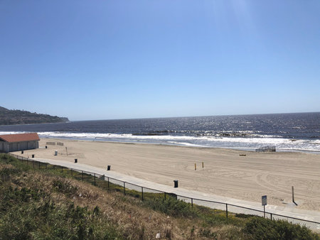 Calm Beach Scene With Gentle Waves and Clear Skies on a Sunny Afternoon Near the Coastの写真素材