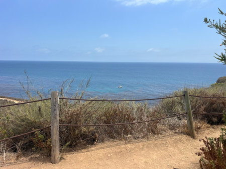 Scenic Coastal View With Vibrant Blue Ocean and Gentle Waves Under a Clear Skyの写真素材