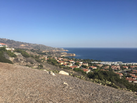 Stunning View of Coastal Cliffs and Tranquil Waters Near a Vibrant Seaside Communityの写真素材