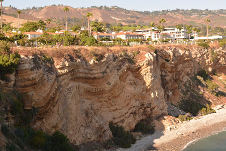 Scenic Coastal Cliffs With Unique Geological Formations Under a Warm Sunset Skyの写真素材