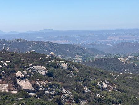 Scenic View of Rolling Hills and Rocky Terrain in a Sunny Landscape During Middayの写真素材