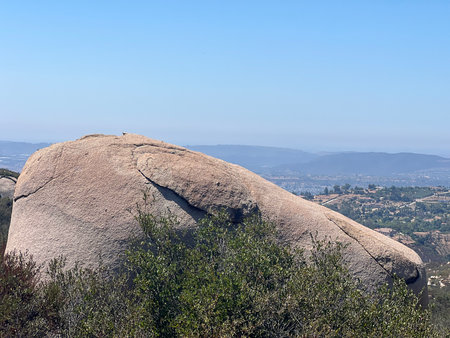 Unique Natural Rock Formation Resembling a Giant Head in a Serene Mountain Landscapeの写真素材
