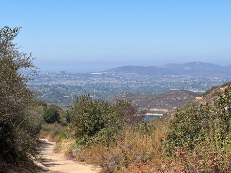 Scenic Hiking Trail Offers Breathtaking Views of the Valley and Distant Mountains in Bright Daylightの写真素材