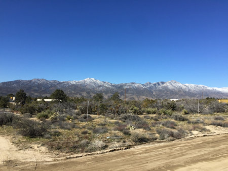 Mountain Landscape Blanketed in Snow Under a Bright Blue Sky During Mid-Morning Hoursの写真素材