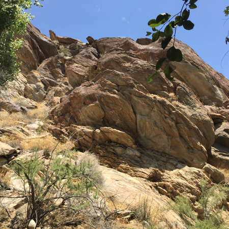 Climbing Rugged Cliffs Under a Bright Blue Sky in a Serene Desert Landscapeの写真素材