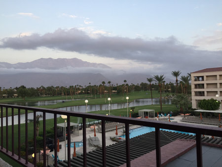 Scenic View of a Tranquil Resort Landscape at Dusk With Mountains in the Background and Poolside Lounge Areaの写真素材