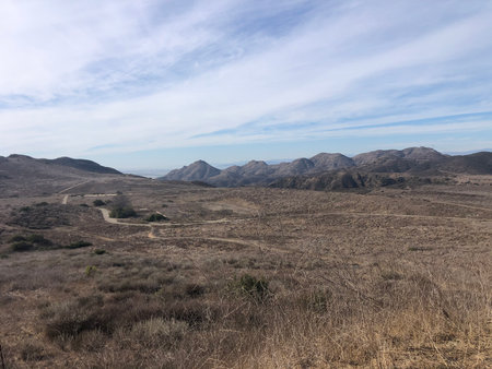 Vast Open Landscape Featuring Rolling Hills and a Serene Sky at an Outdoor Location Under Bright Daylightの写真素材
