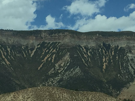 Dramatic Mountain Landscape Showcasing Unique Geological Formations Under a Blue Sky With Fluffy Cloudsの写真素材