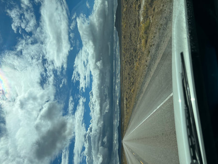 Open Road Stretches Ahead Beneath a Vast Sky Filled With Dramatic Clouds in the American Westの写真素材